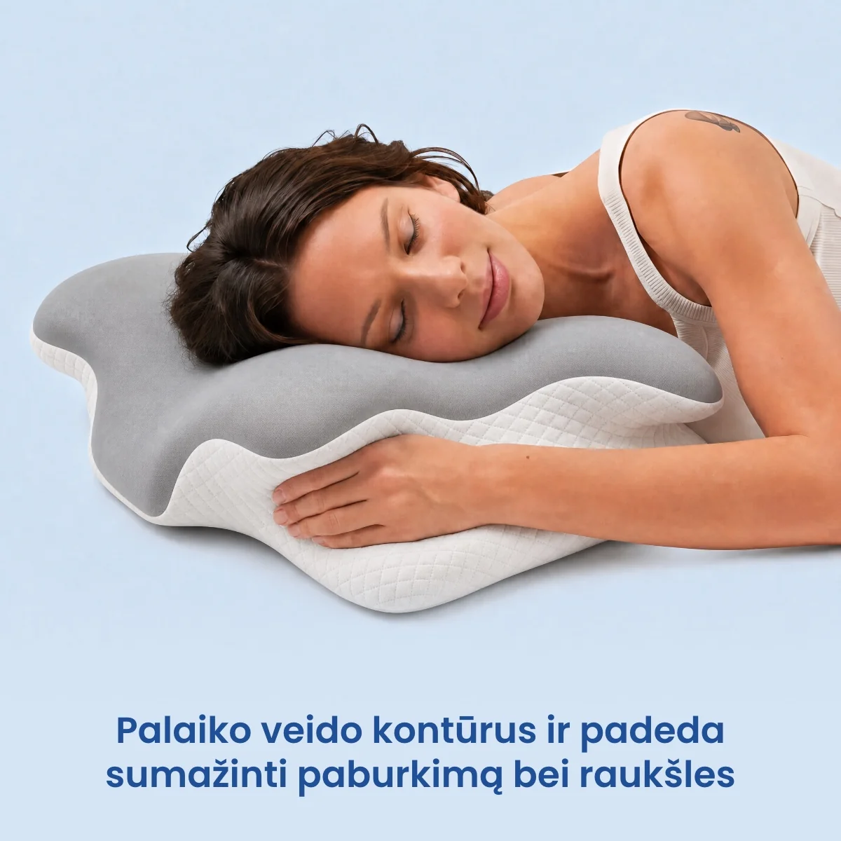 Moteris miega apkabinusi ergonominę pagalvę